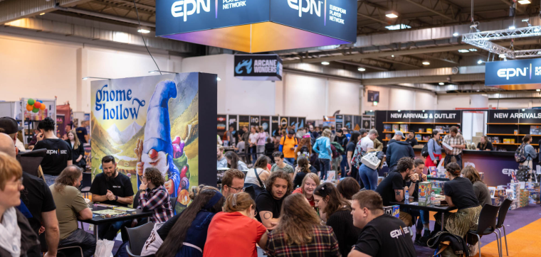 A vibrant scene at the European Player Network (EPN) booth during SPIEL ESSEN 2024. Attendees are engaged in board game demos at tables, with a large illustrated display of 'Gnome Hollow' in the background. The EPN booth features a modern design with prominent branding, and shelves labeled 'New Arrivals & Outlet' showcase various board games. The atmosphere is lively, with players, publishers, and visitors interacting and enjoying the convention experience.